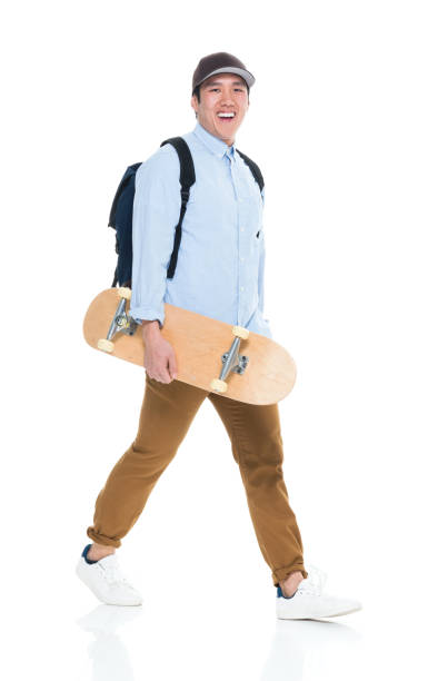 istock Happy Korean Male Student Walking With Skateboard 923875978