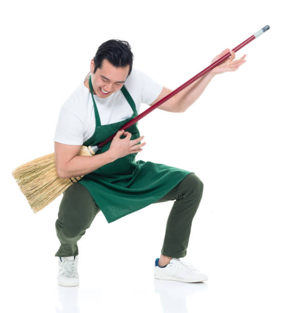 Handsome Korean male wearing a green apron and playing broom guitar Handsome Korean male air guitar stock pictures, royalty-free photos & images