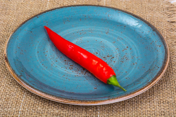 istock Pod of red chili peppers on fabric background 923881010