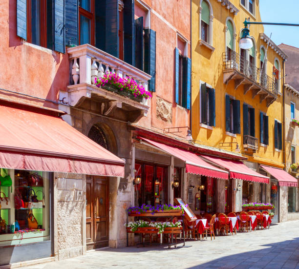 晴れた朝、ヴェネツィア、イタリアでカフェのテーブルとカラフルな通り。 - italy house sunny outdoors ストックフォトと画像