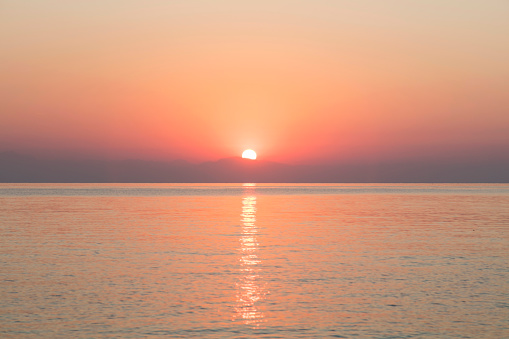 View of a beautiful sunset next to a lighthouse on the Normandy coast in France.