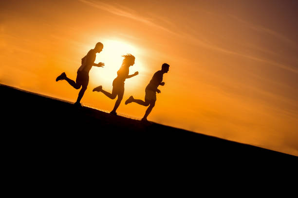 istock People running at beach. Group of people training at morning. 923897546