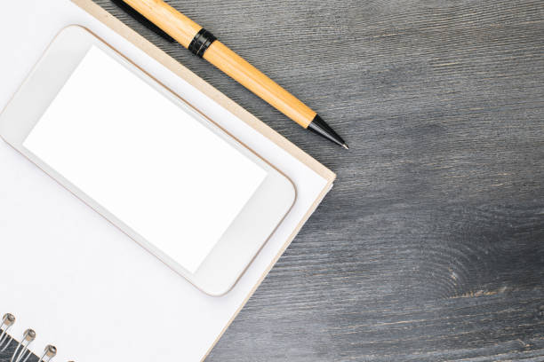 istock Desk with empty white smartphone and supplies 923898766