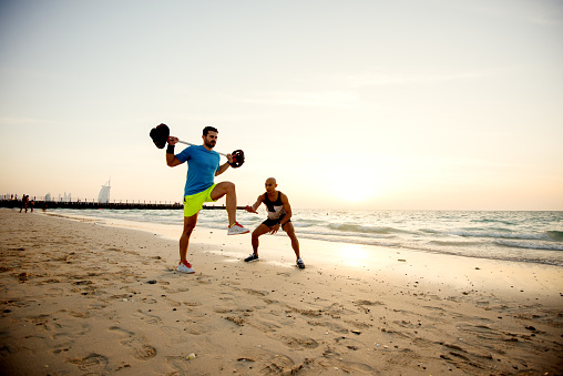Fitness people at the beach doing exercises.