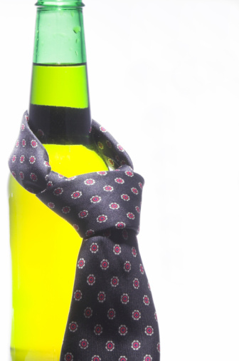 A necktie draped around an ice cold beer.