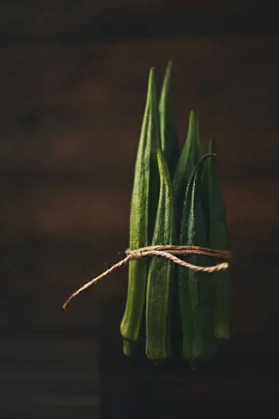 Still life of bundled okra shot in dark moody light
