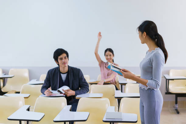 istock Young woman standing present friend student in a classroom showing ready answer. concept of education. 923949688