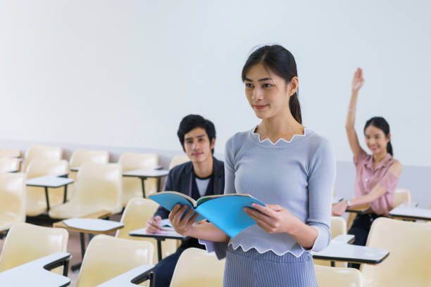 istock Young woman standing present friend student in a classroom showing ready answer. concept of education. 923949712