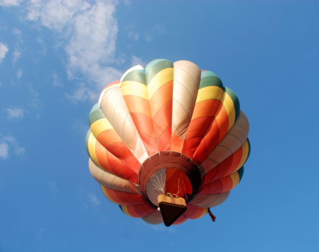 Colorful hot air balloon ascending into blue sky