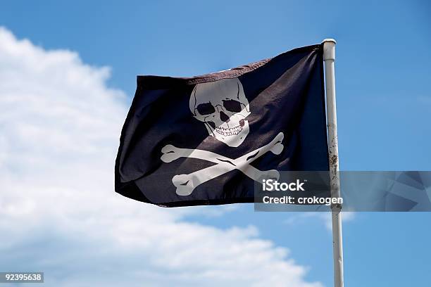 Jolly Roger Bandera Contra El Cielo Azul Foto de stock y más banco de imágenes de Azul - Azul, Bandera, Bandera de piratas