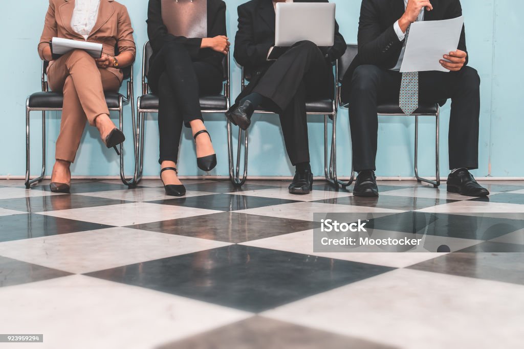 Four applicants  sitting on chairs and preparing for employment interview. Interview - Event Stock Photo