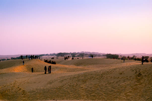 istock People enjoying the sunset on sand dunes 923977306