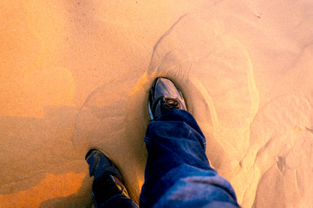 Man wearing running shoes in the sand
