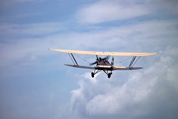 istock Biplane Flies Toward Clouds in Distance 92397922