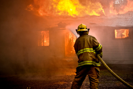 Bombero pulverización de agua en una casa de incendios photo