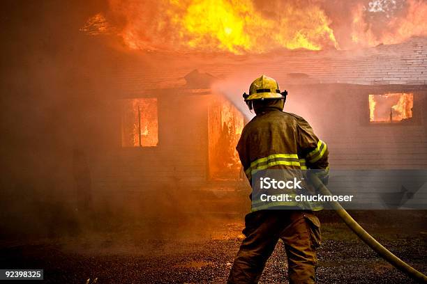 Firefighter Spraying Water At A House Fire Stock Photo - Download Image Now - Fire - Natural Phenomenon, Firefighter, House