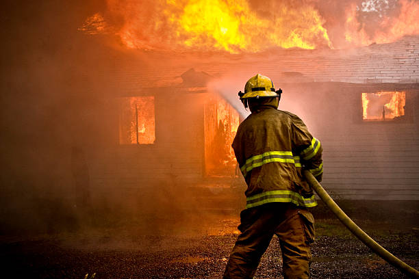 bombeiro jogando água em uma casa de incêndio - house fire - fotografias e filmes do acervo