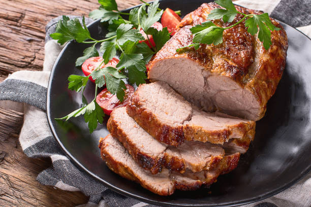 Roast pork with herbs and vegetables Roast pork with herbs and vegetables on rustic wooden table. roasted stock pictures, royalty-free photos & images