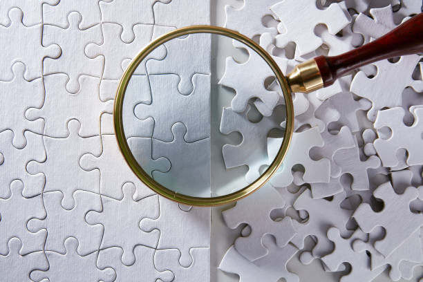 istock Looking at puzzle with magnifying glass 923994610
