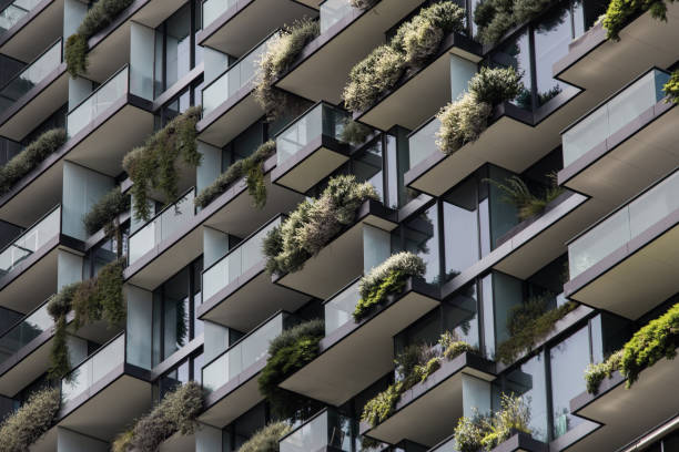 Green Apartment Glass window with plant of an apartment. green skyscraper stock pictures, royalty-free photos & images