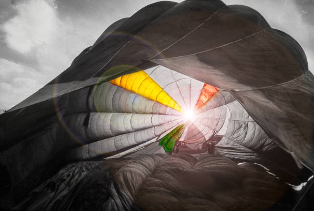 canopy of a parachute in backlight effects of lights and colors with a canopy of a parachute black and white balloons stock pictures, royalty-free photos & images