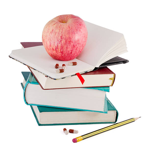 pastillas y red apple en libros - book stack dieting textbook fotografías e imágenes de stock