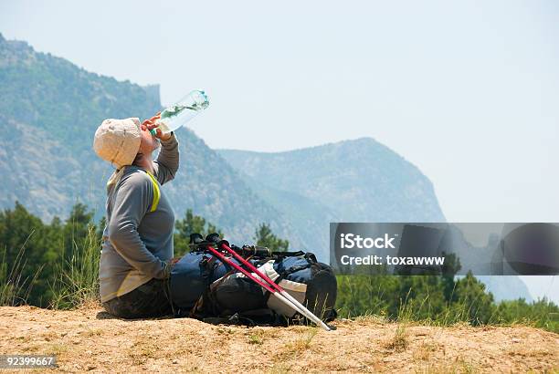 Foto de Cansado Alpinista Bebidas Água De Uma Garrafa Na Montanhas e mais fotos de stock de Adulto