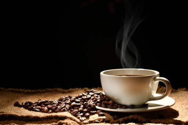 istock Cup of coffee with smoke and coffee beans on black background 924006038