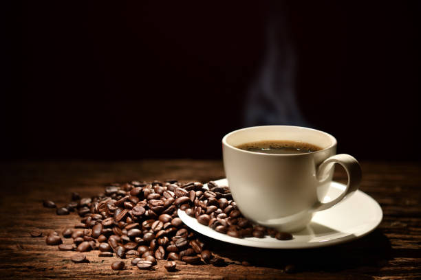 istock Cup of coffee with smoke and coffee beans on black background 924006566