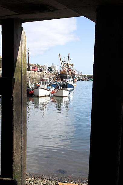 istock View of Boats Framed By Quay Structure Newlyn Cornwall UK 92400878