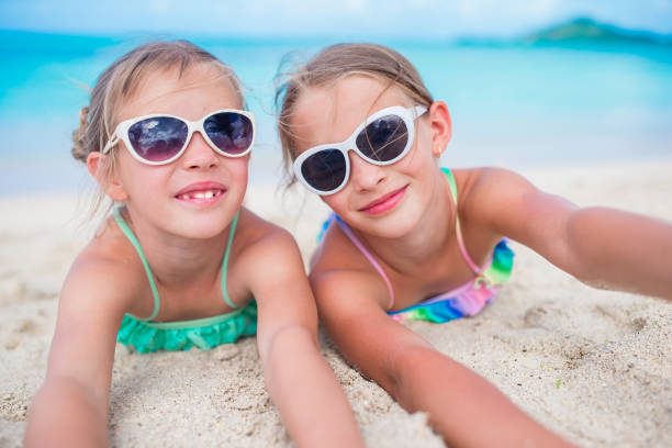 istock Adorable little sisters at beach during summer vacation lying on warm sand 924011214