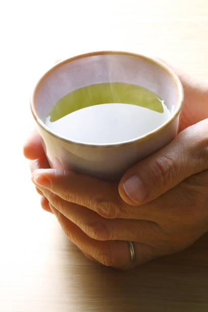 istock Hand of an old man with Japanese tea cups 924015340