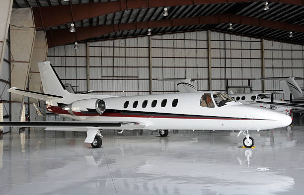 Sleek white private jet, positioned in a hangar
