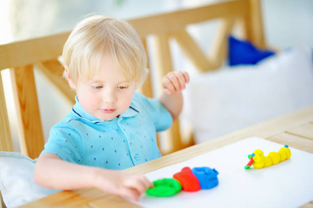 istock Creative boy playing with colorful modeling clay at kindergarten 924020144
