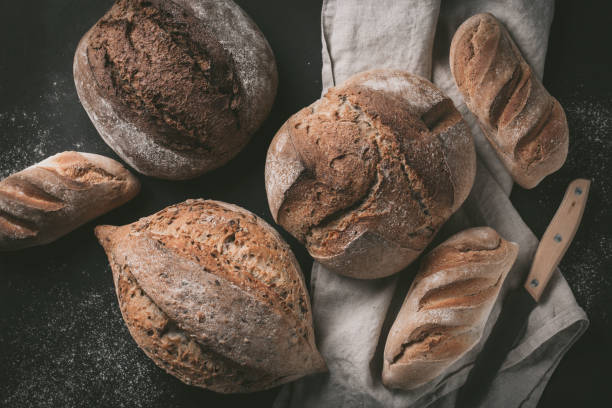 istock Flat-lay of various bread selection. Multigrain rustic bread on kitchen towels over grey background, top view, copy space 924023308
