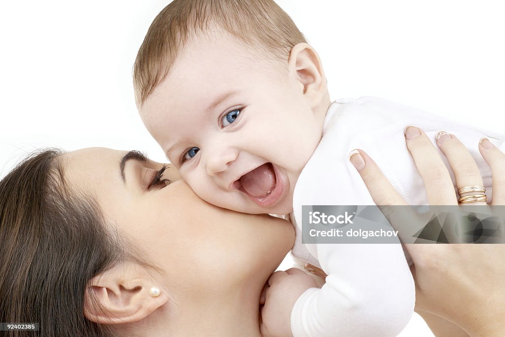 happy mother kissing her baby over white people, motherhood, parenting and family concept - happy mother kissing her baby over white Baby - Human Age Stock Photo