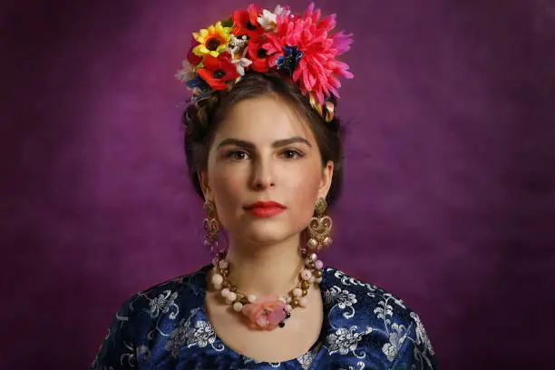 Beautiful young woman with red lips and flowers over purple background