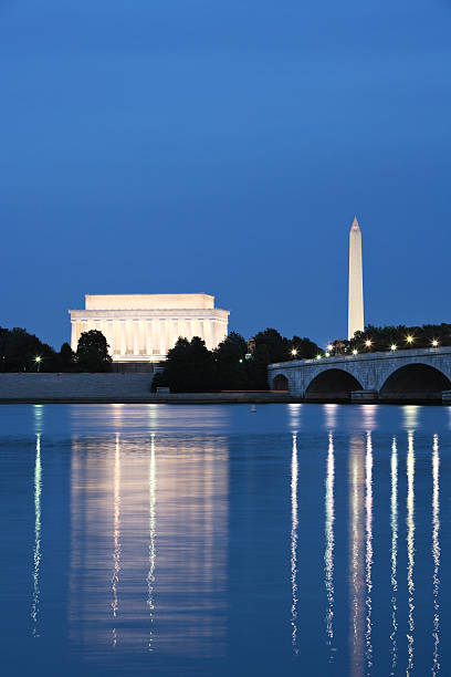 A night time photo of Washington DC monuments Night view of the Lincoln Memorial and Washington Monument reflected in the Potomac River.  potomac river photos stock pictures, royalty-free photos & images