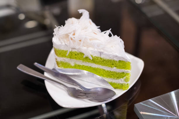 istock Pandan cake topped fresh coconut in creamy layers on white plate 924037986