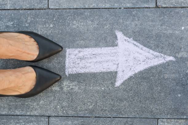 Feet and arrow on road.