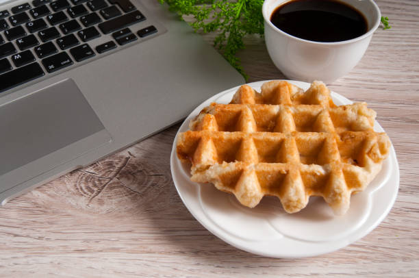 istock Notebook with hot coffee with wafer on wood table 924045332