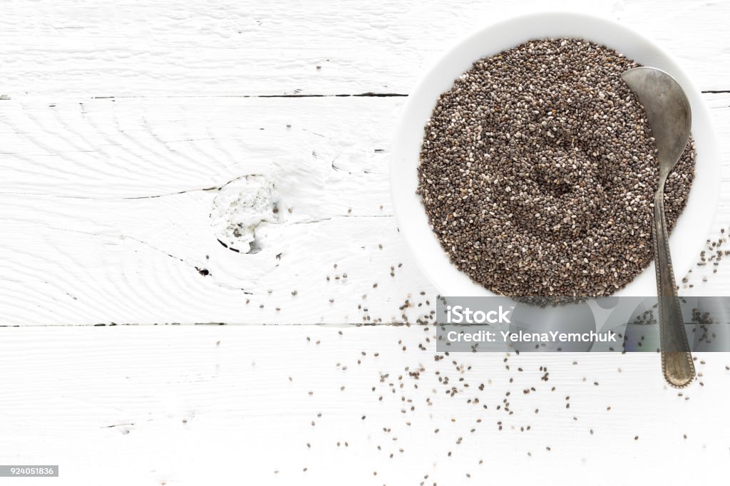 Chia seeds in bowl on white wooden background. Top view Chia seed Stock Photo