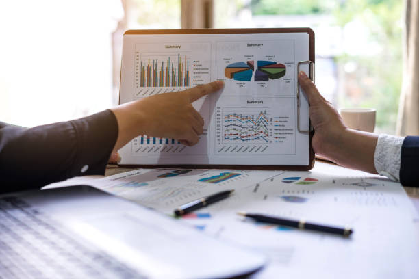istock financial Image of two  business people pointing at business document presentation summary report , during discussion at meeting , Notebook on wood table 924052034