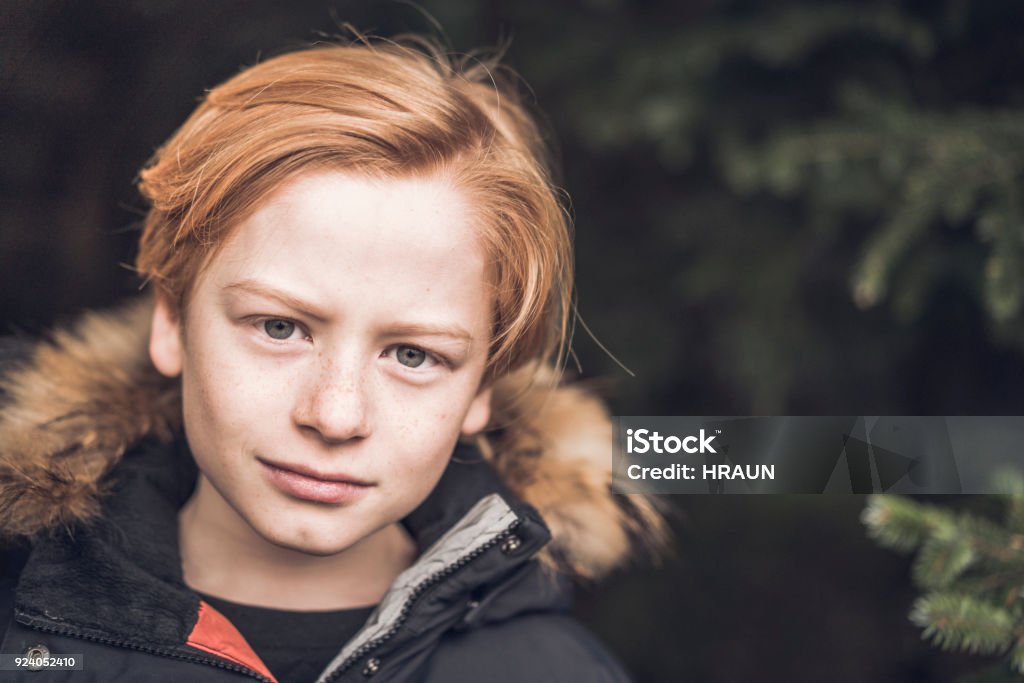 Close-up portrait of confident boy in forest Close-up portrait of boy in forest. Confident male is with red hair. He is in woods. 10-11 Years Stock Photo