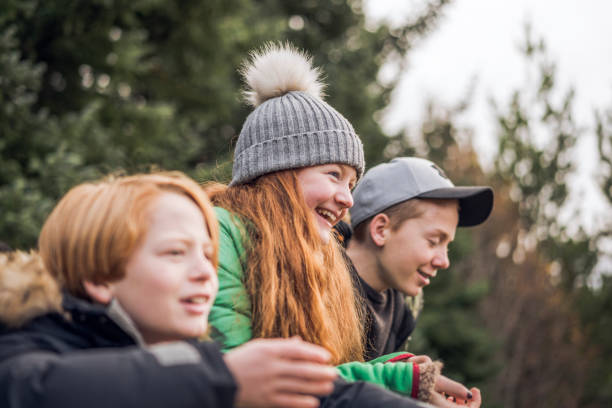 istock Smiling girl with brothers relaxing in forest 924052498