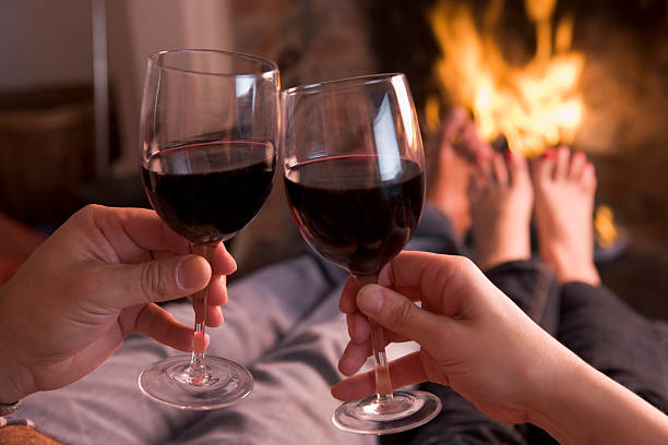 istock Feet warming at fireplace with hands holding wine 92405342