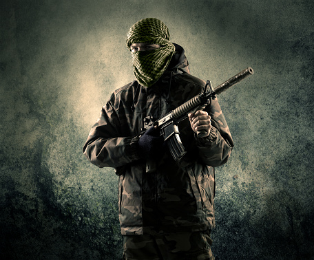 Retrato de un soldado enmascarado fuertemente armado con fondo Grunge photo