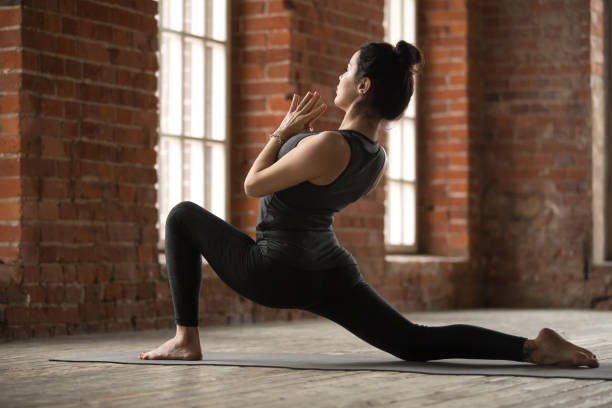 istock Young woman doing anjaneyasana exercise 924059506