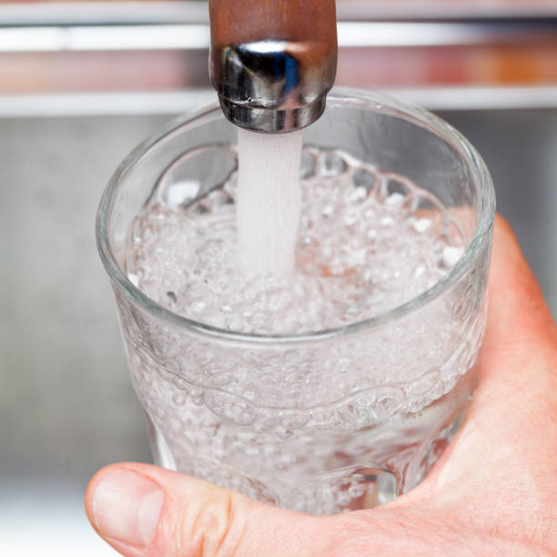 istock Filling up a glass with raw water from kitchen faucet 924068208