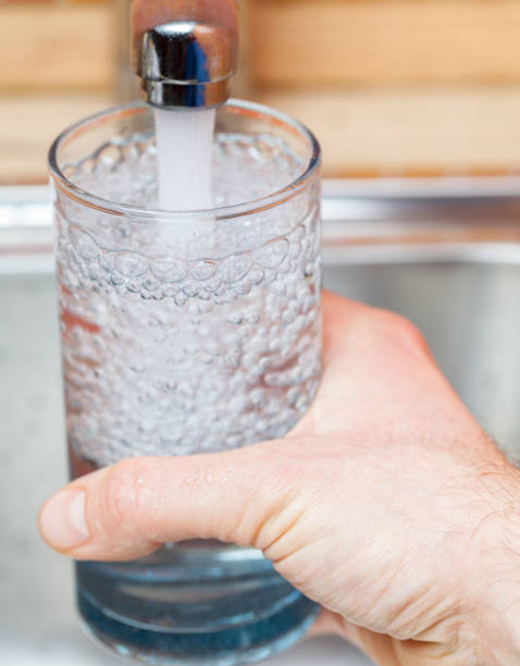 istock Filling up a glass with raw water from kitchen faucet 924068216